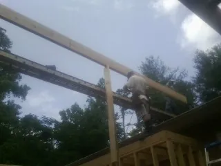 Carpenter setting a ridge beam over a new addition frame — Ice Dam Removal by Roofing Brothers in Stacy