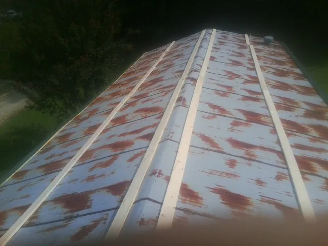 Rusted metal roof panels with new wood purlins before replacement — Storm Damage Roof Repair in Stacy by Roofing Brothers