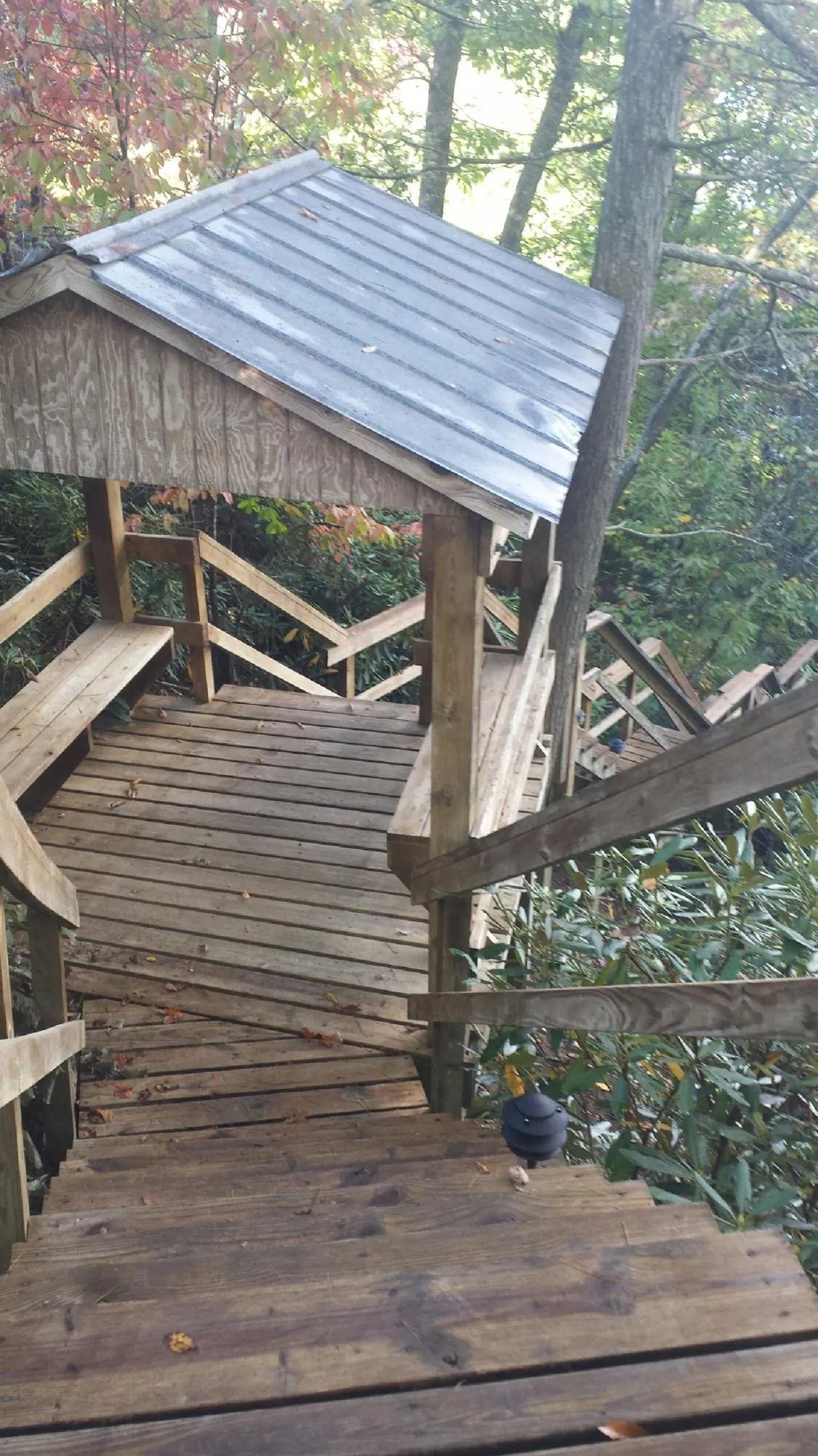 Metal roofed shelter over wooden steps on a wooded walkway — Skylight Repair & Installation work by our crew in Stacy