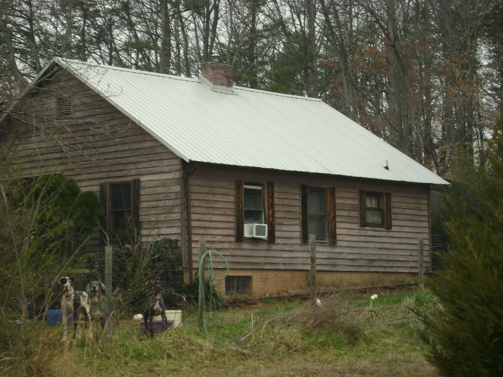 White metal roof on an old wood sided farmhouse, from a Metal Roof Installation job in Stacy